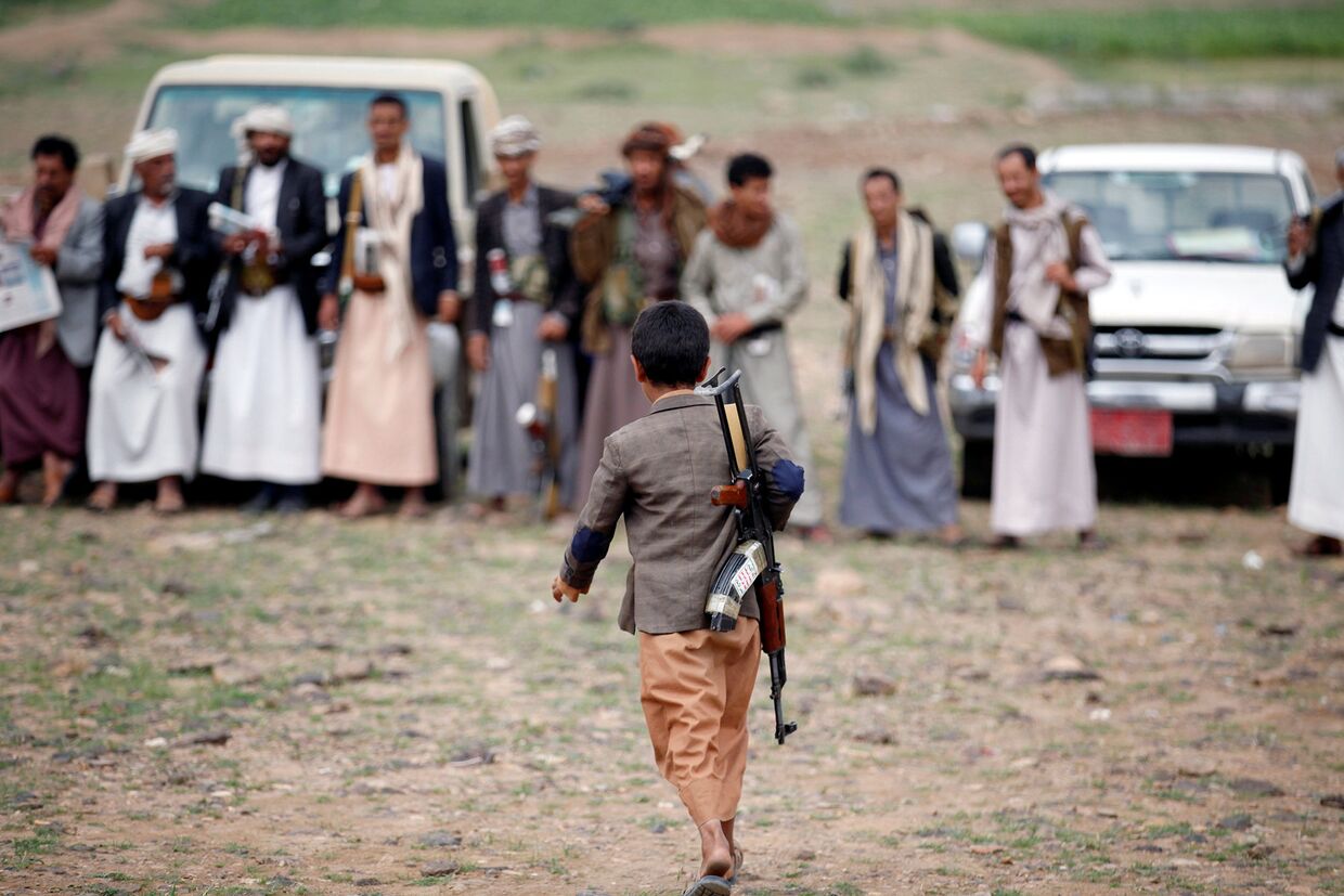 Вооруженный мальчик идет на собрание лояльных по отношению к движению Хути, Йемен. Август 2016