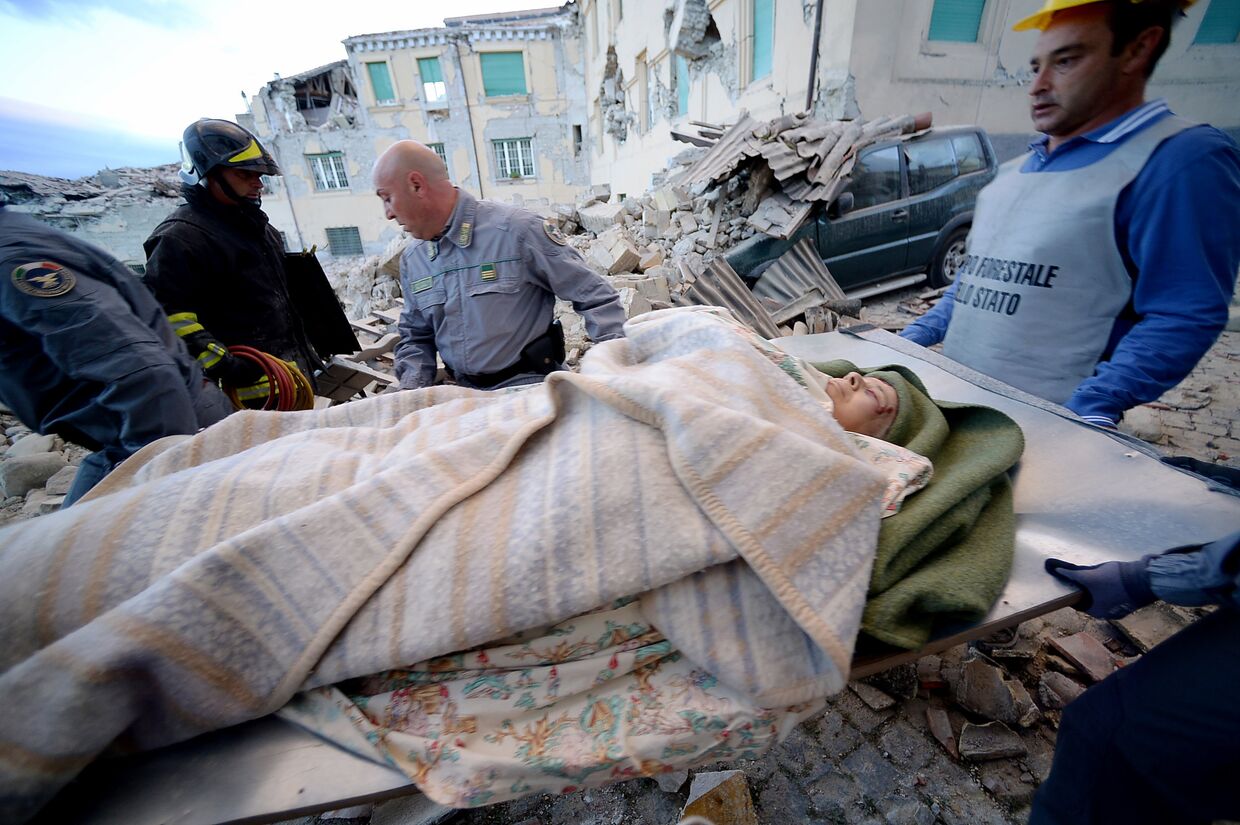 Спасатели эвакуируют пострадавших от землетрясения в итальянском Аматриче. 24 августа 2016