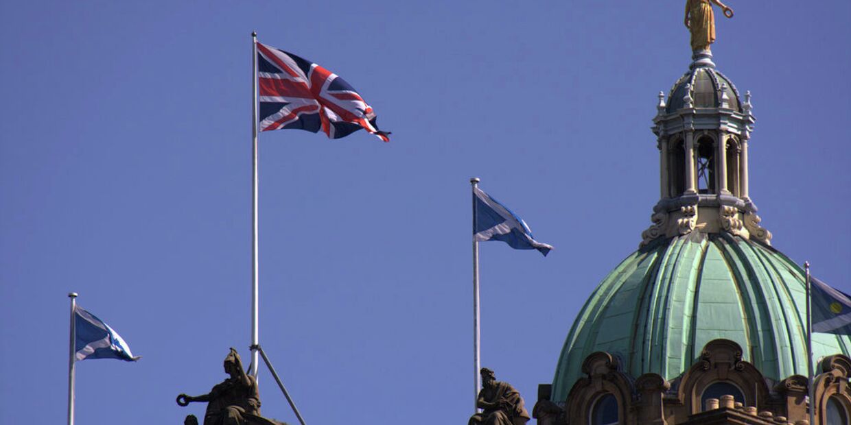 Британский и шотландский флаги на здании банка Lloyds в Эдинбурге