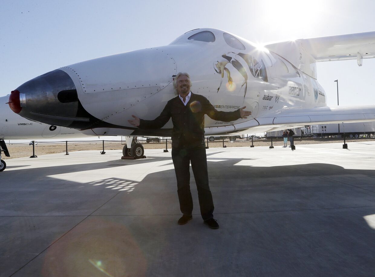Британский бизнесмен Ричард Брэнсон позирует с частным пилотируемым суборбитальным космическим кораблем многоразового использования SpaceShipTwo
