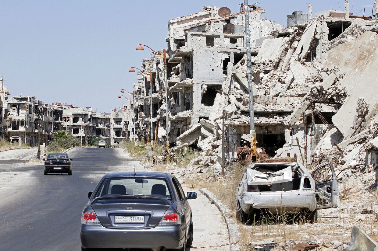 Поврежденные здания и автомобили в Хомсе