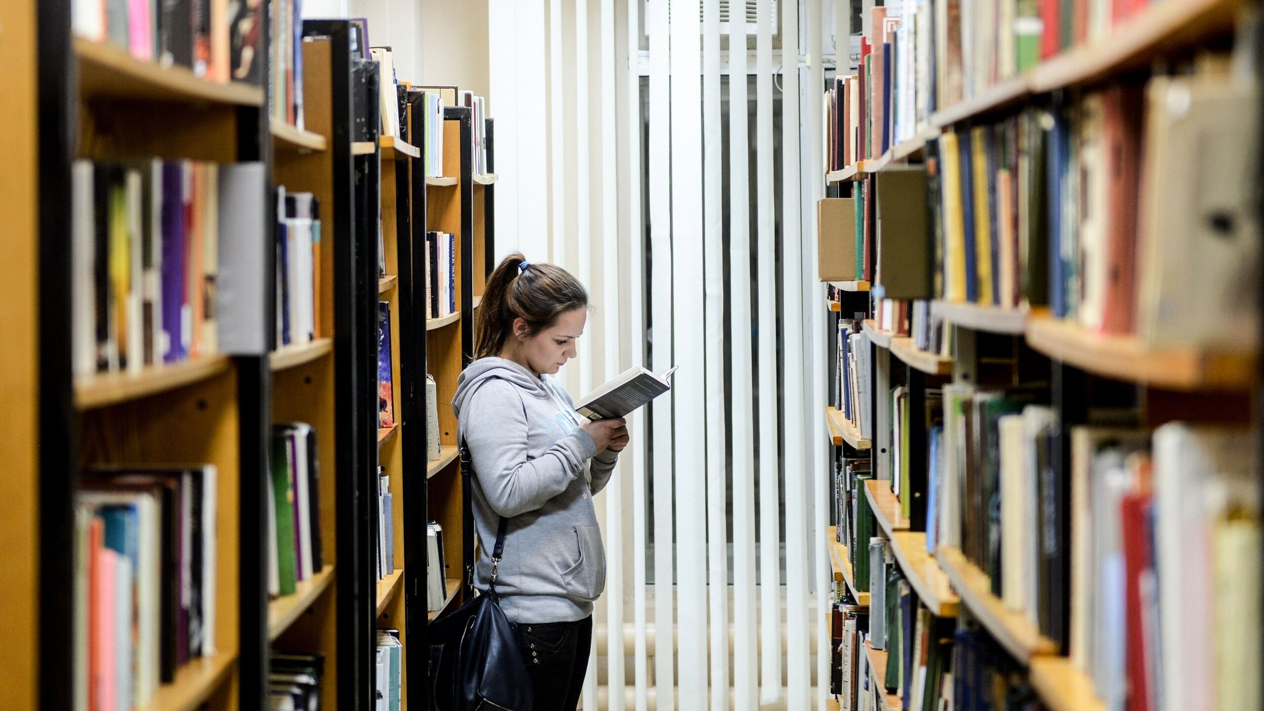 Библиотеки читать литературу. Читатели в библиотеке. Девушка в библиотеке.