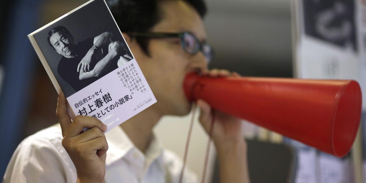 Продавец рекламирует новй роман Харуки Мураками