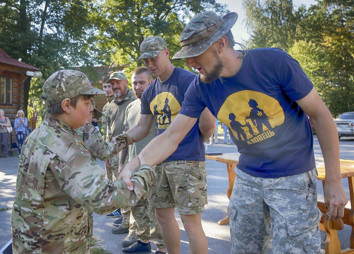 Инструкторы награждают грамотами детей, закончивших подготовку в украинском добровольческом батальоне «Азовец»