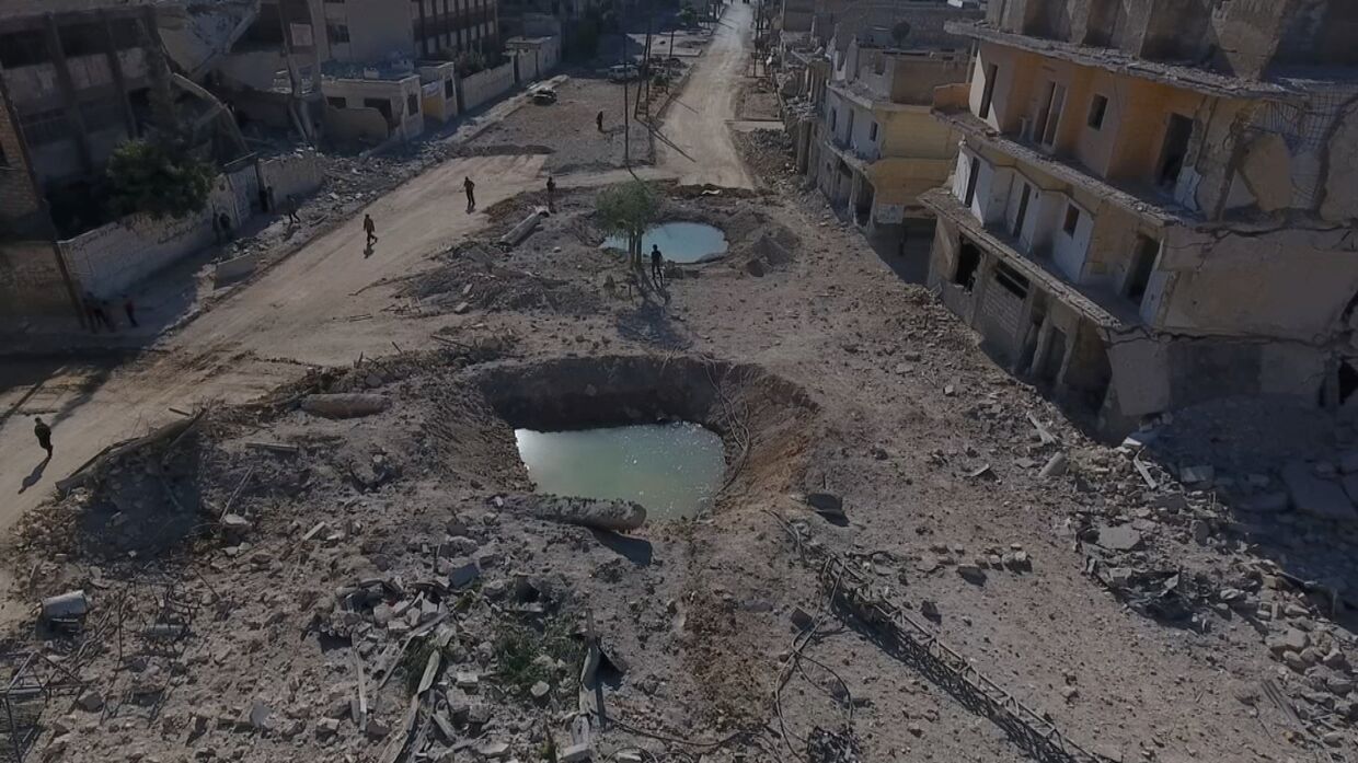 Воронки и разрушенные здания в районе, контролируемом повстанцами Алеппо