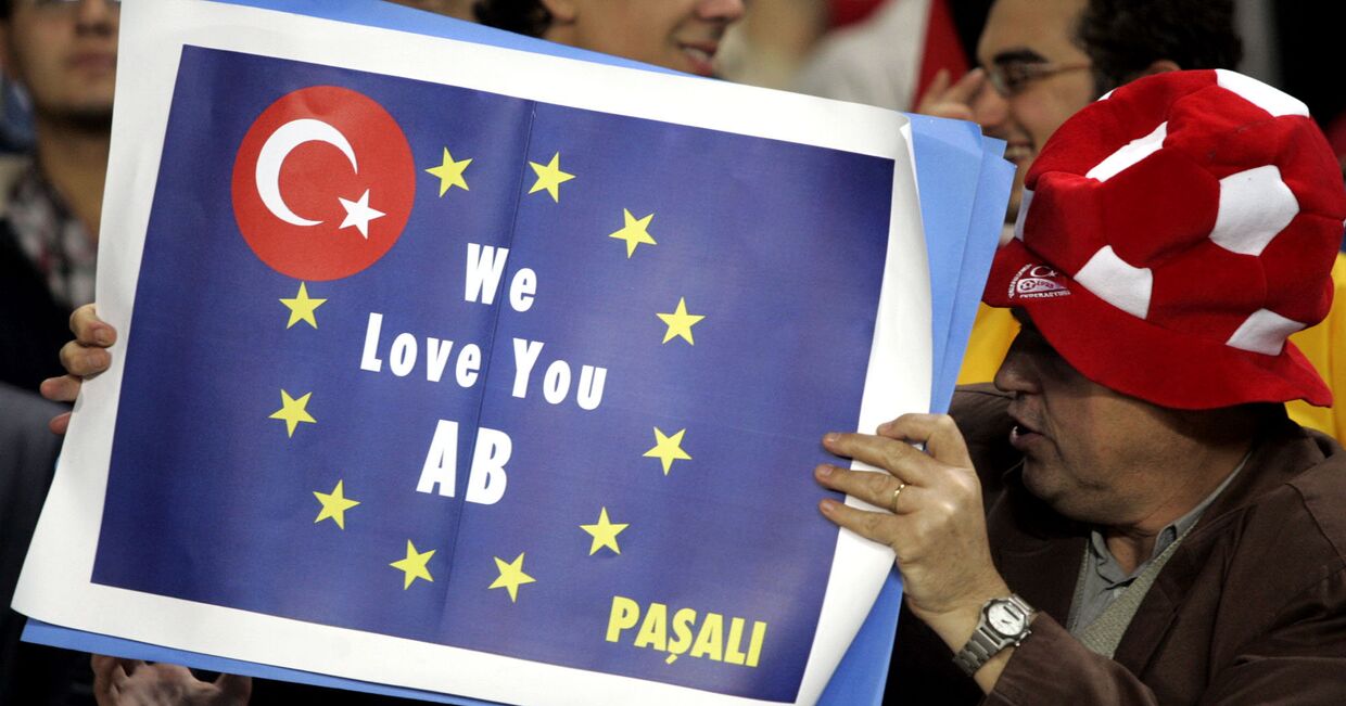Турецкие футбольные фанаты с транспарантом, на котором написано: «Мы любим тебя, ЕС»