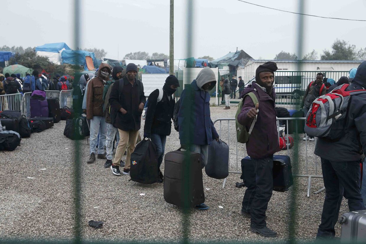 Мигранты ожидают эвакуации во время сноса лагеря «Джунгли»