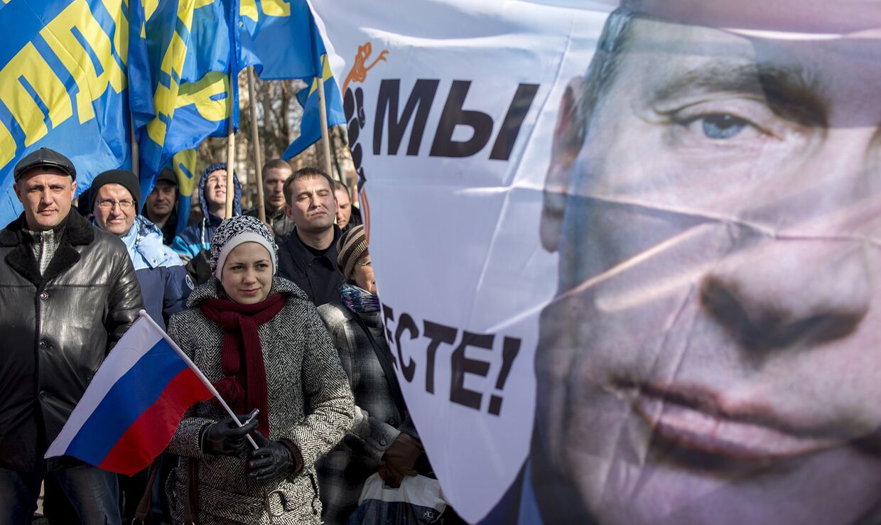 Плакат с изображением президента РФ Владимира Путина во время митинга в Симферополе