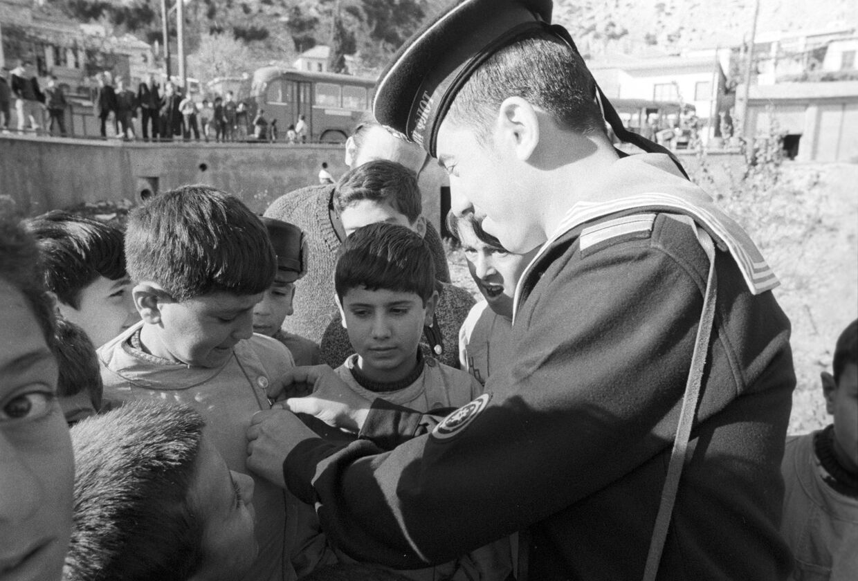Визит советских кораблей в Сирийскую Арабскую Республику. Советский моряк дарит значки сирийским детям