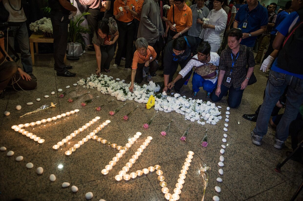 Люди возлагают цветы в память о погибших в авиакатастрофе малайзийского самолета Boeing 777 в районе города Шахтерск Донецкой области. Куала-Лумпур