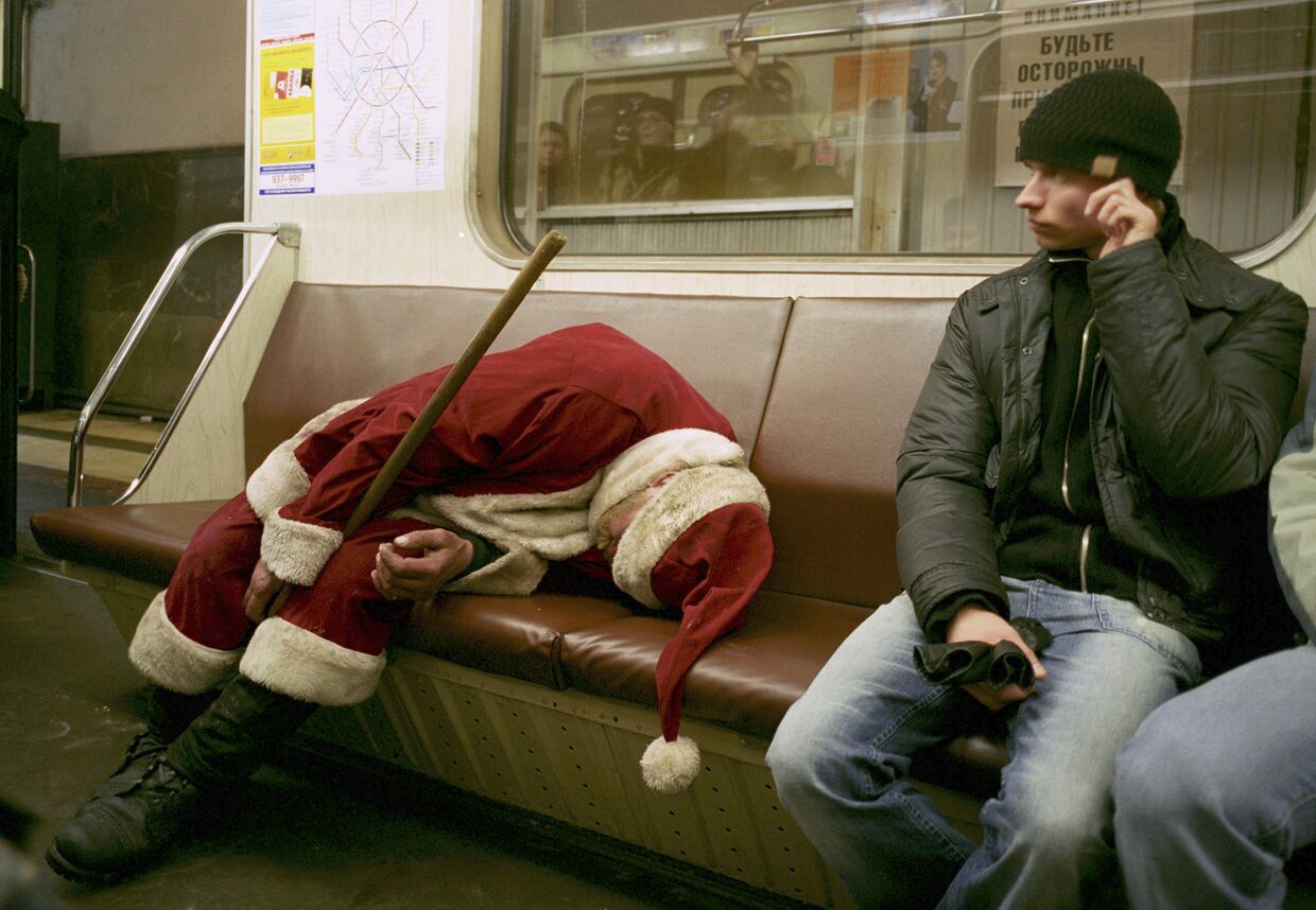 Выпивший человек, одетый Дедом Морозом спит в московском метро