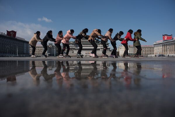 Группа детей на роликовых коньках на площади имени Ким Ир Сена