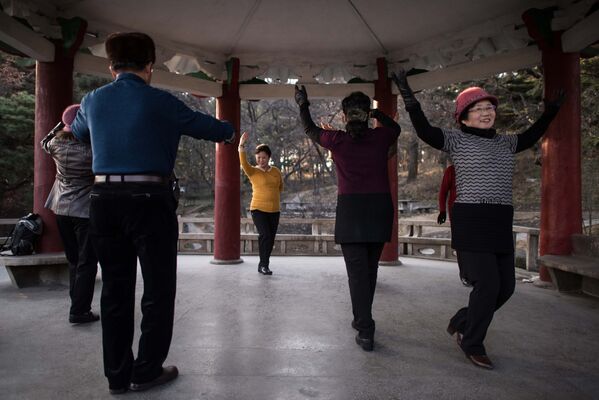 Танцы под народную музыку в одном из парков в Пхеньяне
