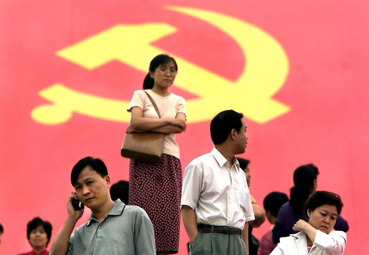 Пекинцы на фоне партийного флага