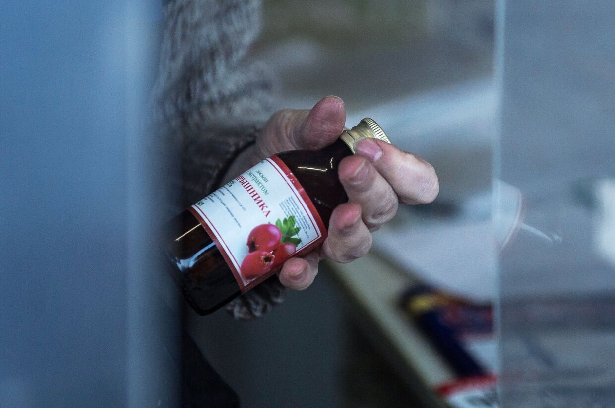 Продавец демонстрирует лосьон с экстрактом боярышника в одном из киосков Омска