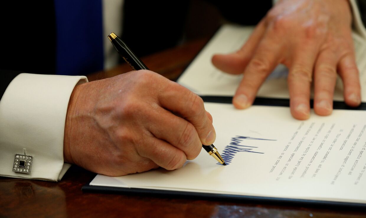 Президент США Дональд Трамп во время подписания документов. 24 января 2017 года