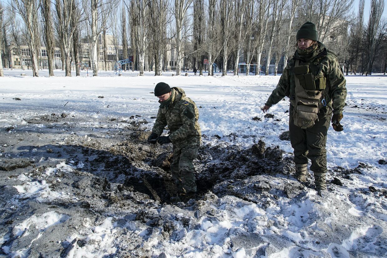 Украинские солдаты на месте взыва снаряда в Авдеевке