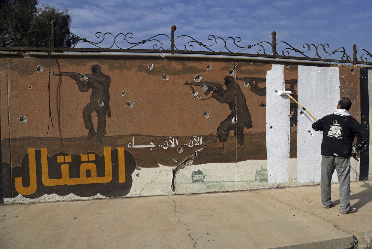 Волонтер закрашивает граффити, оставленное ИГИЛ (запрещена в РФ) в Мосуле