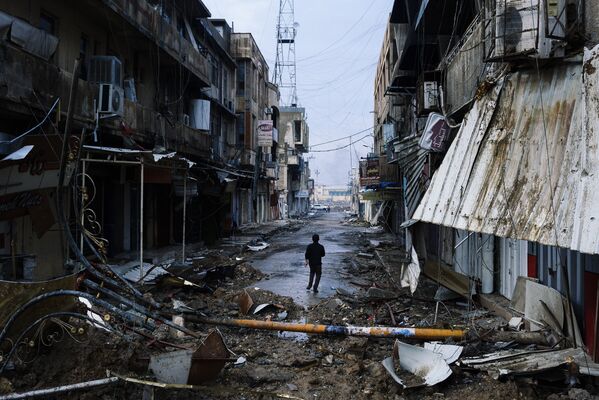 Иракский мальчик идет по разрушенному городу