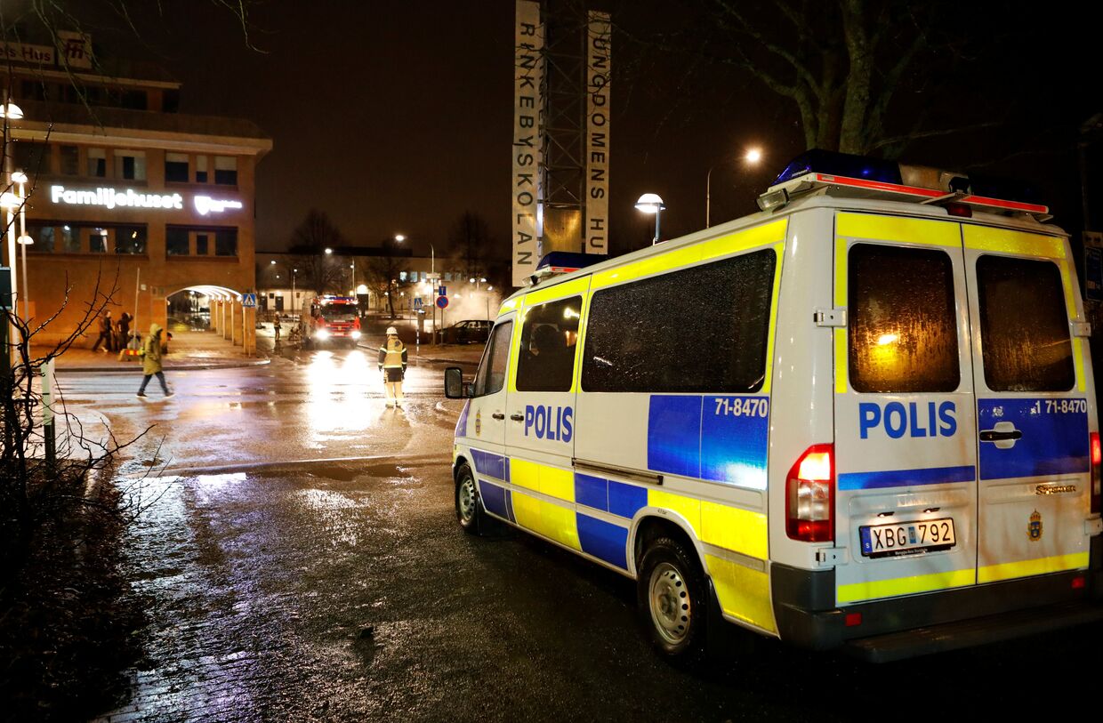 Полицейский автомобиль во время беспорядков в пригороде Стокгольма