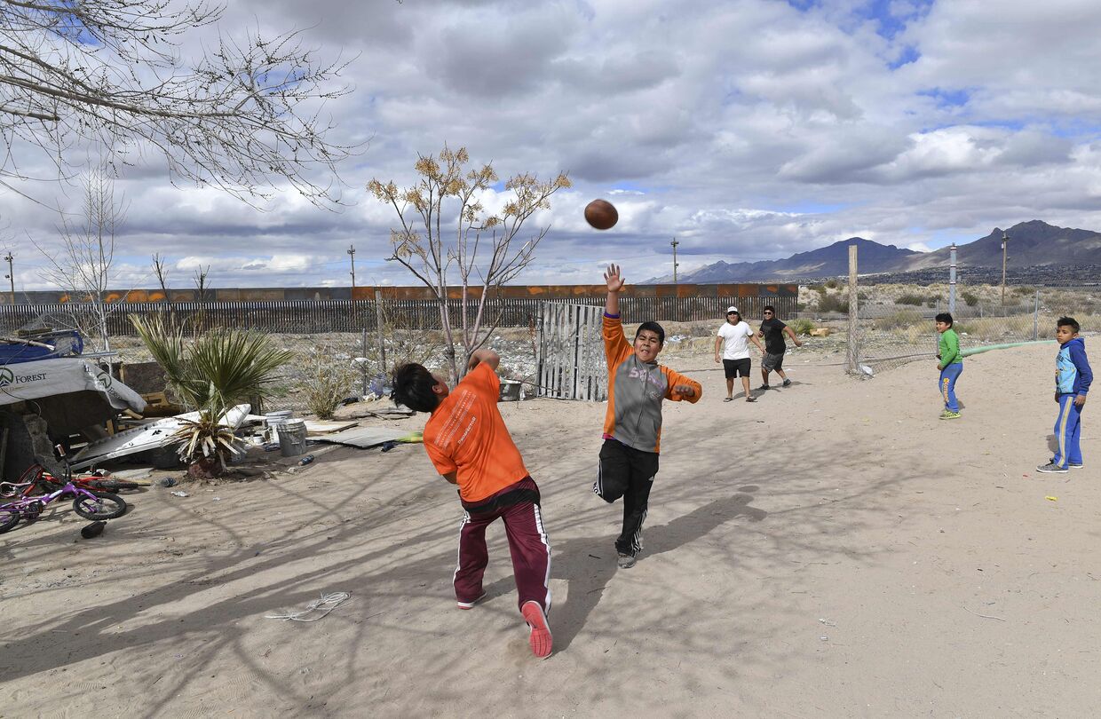 Мексиканские дети играют в Пуэрто Анапре, неподалеку от пограничной стены
