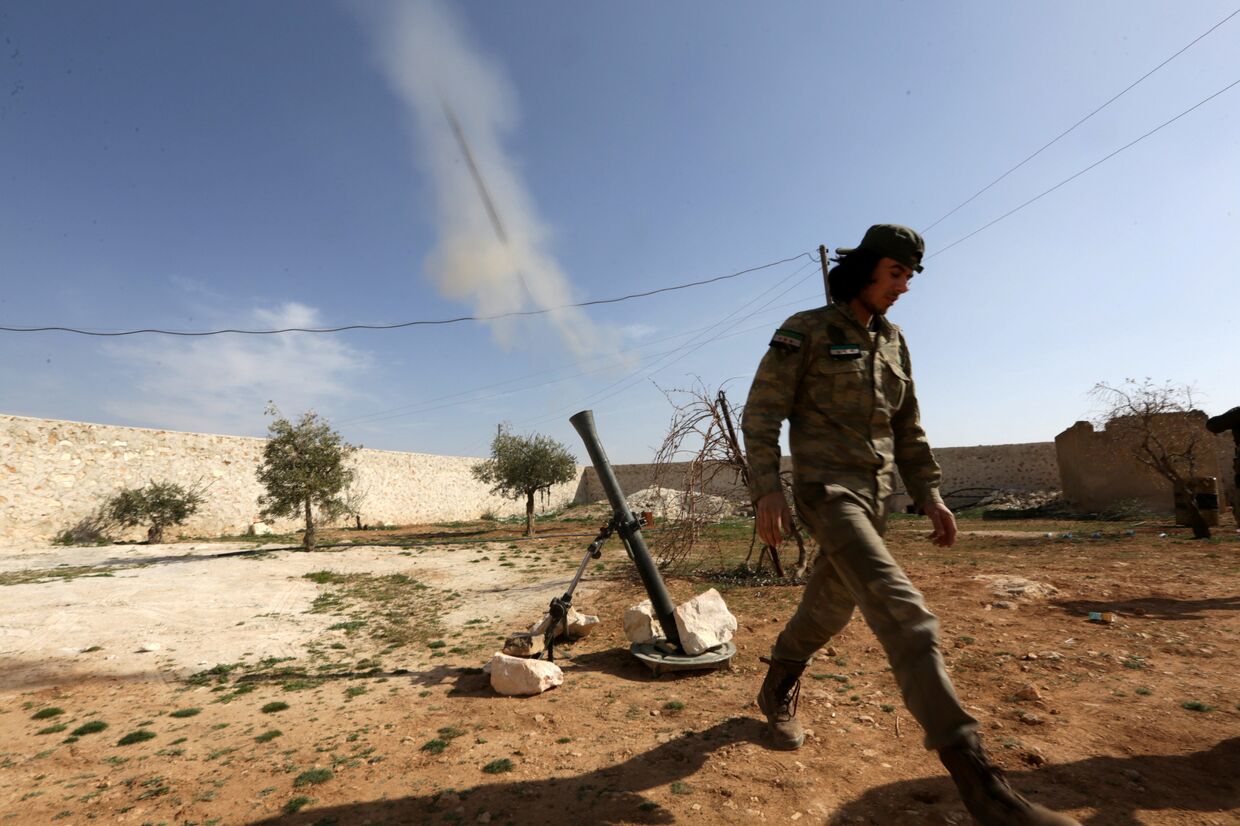 Боевик стреляет из миномета в сторону солдат сирийской армии, на западе от города Манбидж