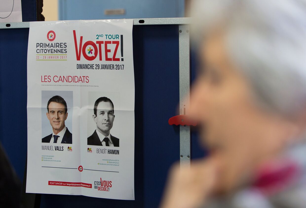 Портреты кандидатов в президенты от Социалистической партии Франции Мануэля Вальса и Бенуа Амона на избирательном участке в Париже. 29 января 2017 года