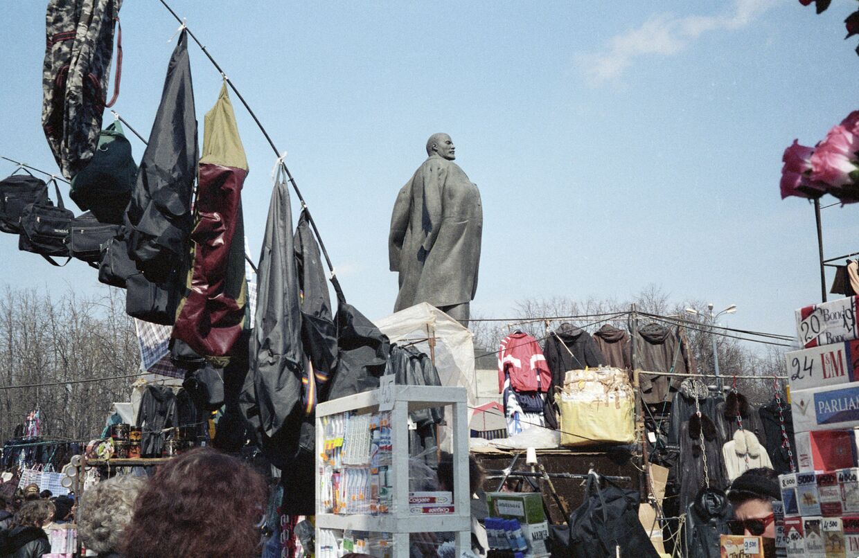Продавцы вещевого рынка в Лужниках ведут торговлю возле памятника Ленину