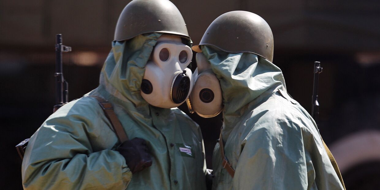 Военнослужащие на боевом посту, одетые в средства химической защиты
