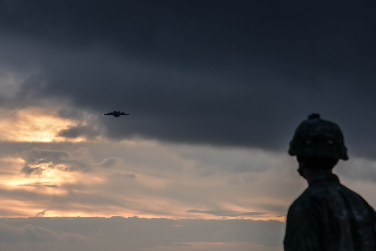 Американский десантник наблюдает за военно-транспортным самолетом