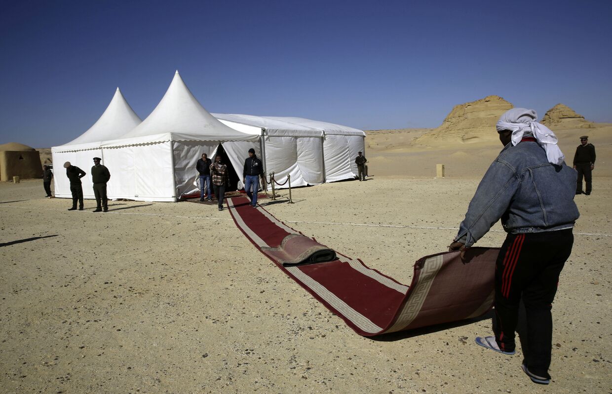 Работники готовят красную ковровую дорожку для VIP-гостей в Египте
