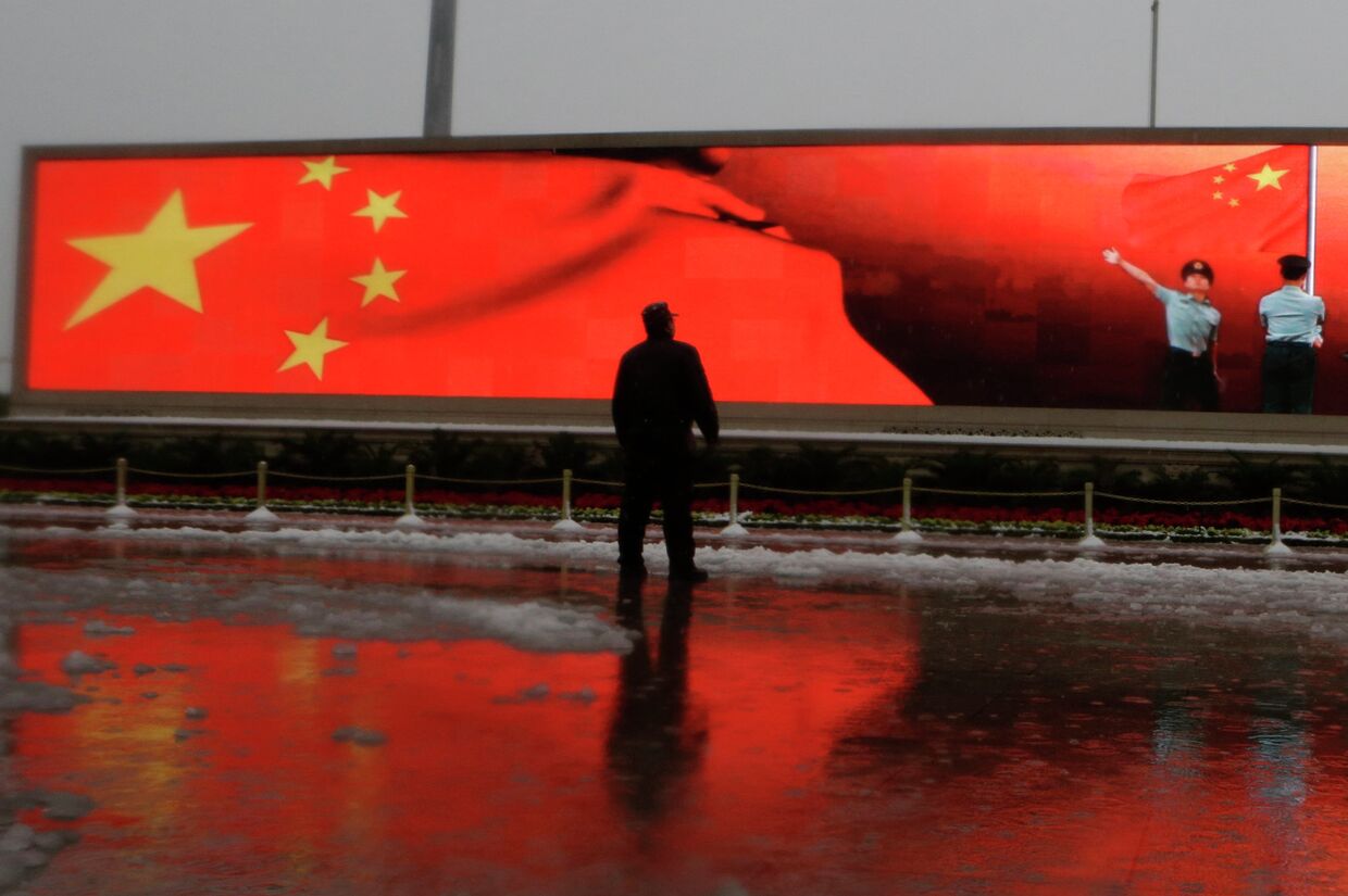 Человек на фоне экрана с флагом Китая, Пекин