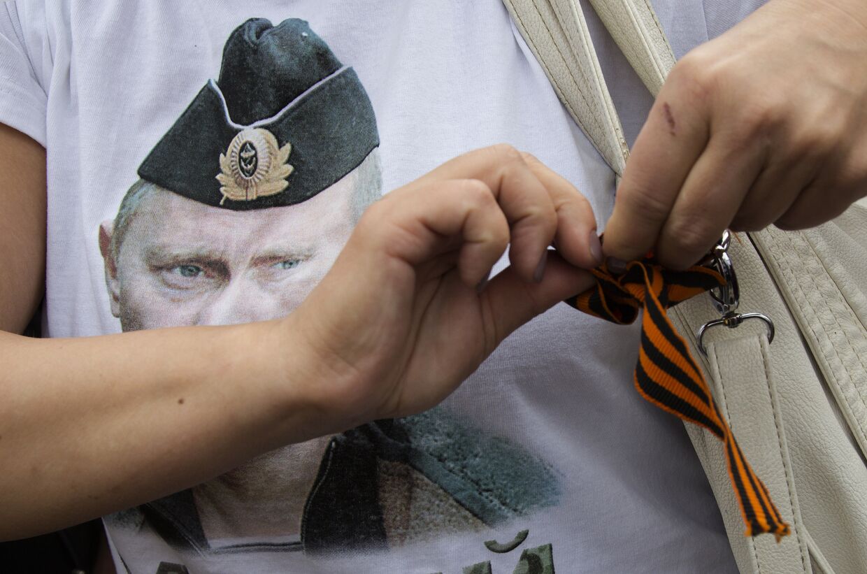 Женщина в футболке с портретом российского президента Владимира Путина во время пророссийского митинга в Донецке