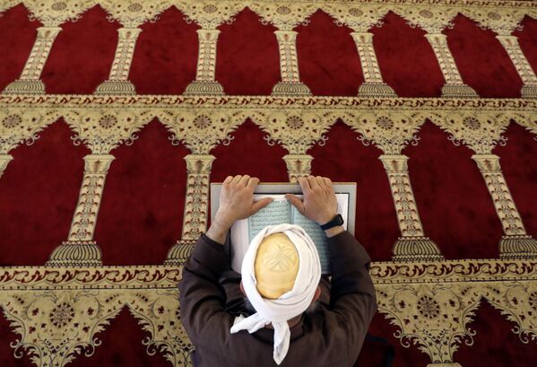 Палестинец читает Коран в мечети Аль-Акса, расположенной на территории Аль-Харам Аш-Шариф