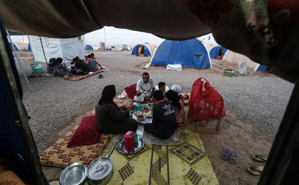 Семья вкушает ифтар в первый день Рамадана в лагере для временно перемещенных лиц