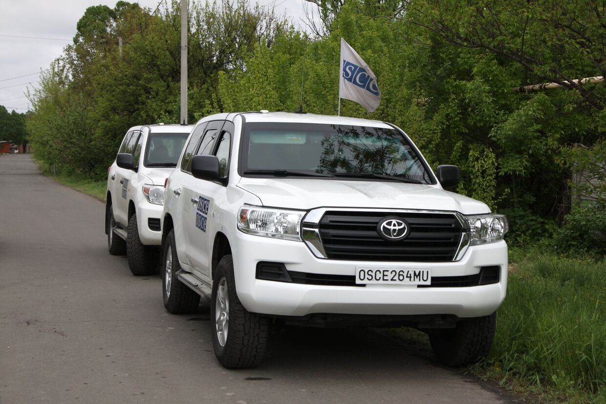 Автомобили ОБСЕ на месте артиллерийского обстрела Куйбышевского района Донецка