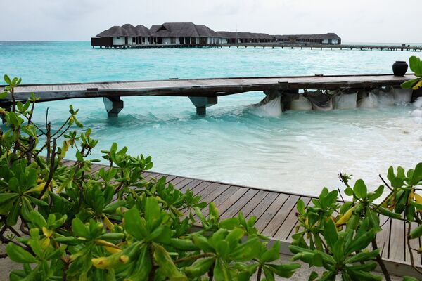 Виллы и мост на сваях в прибрежных водах острова Велассару (Мальдивы)