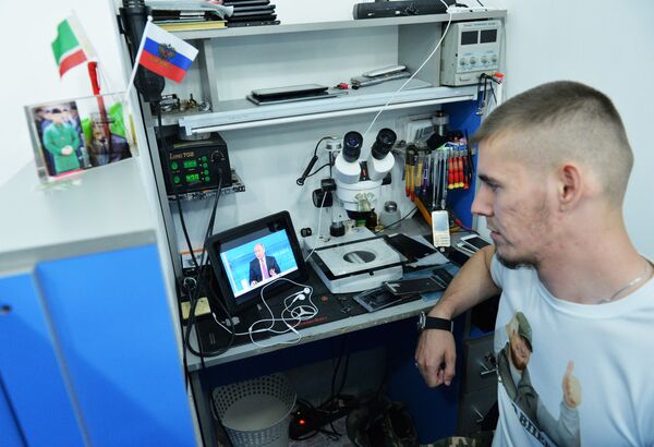 Мужчина смотрит трансляцию «Прямой линии с Владимиром Путиным» в Грозном