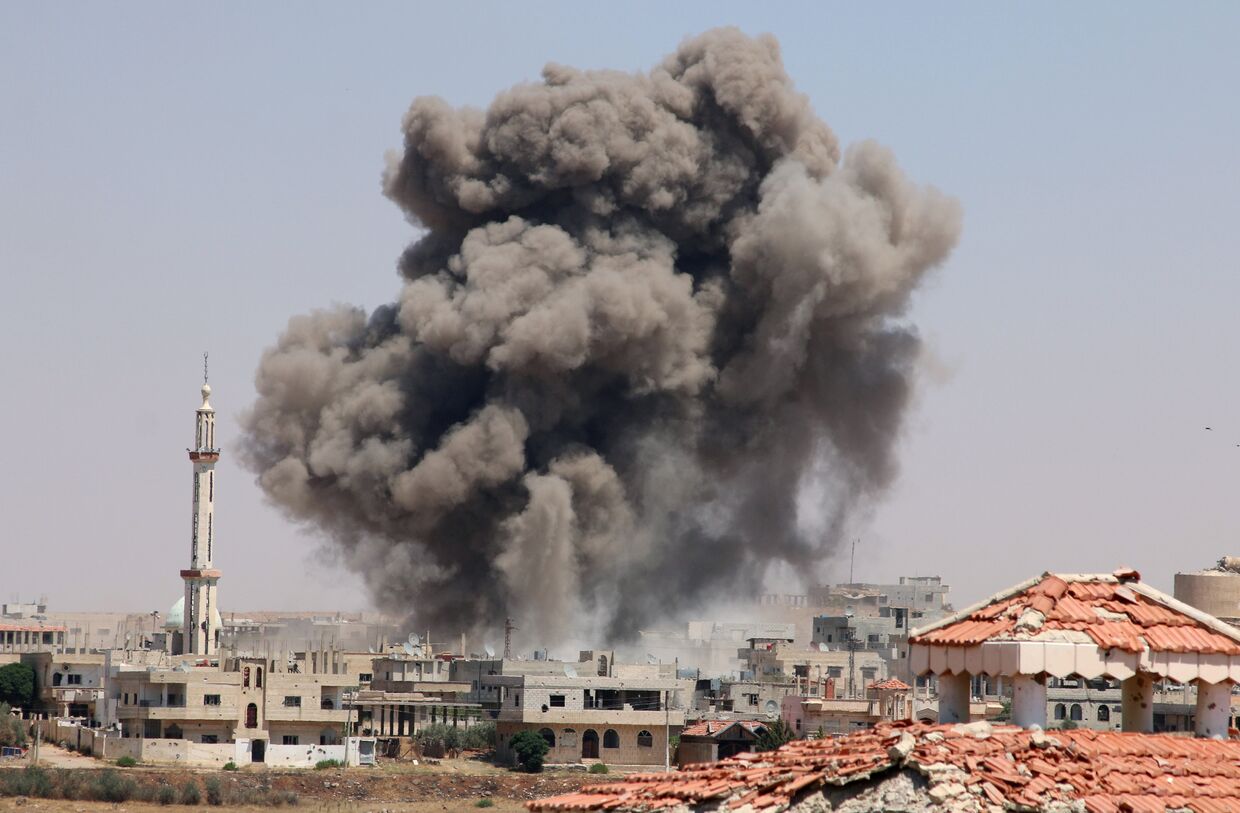 Дым после атаки в городе Деръа, Сирия
