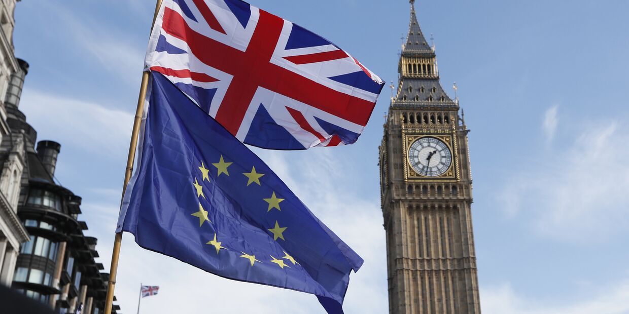 Флаги Евросоюза и Великобритании на фоне часовой башни Вестминстерского дворца в Лондоне