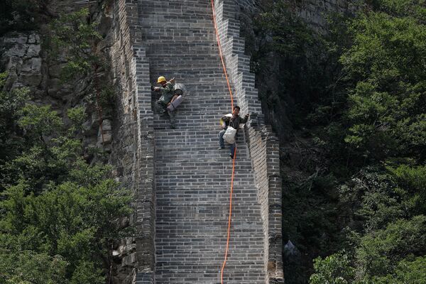Рабочие несут инструменты для реконструкции Великой Китайской Стены