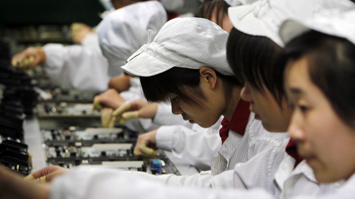 Работники на производственной линии завода Foxconn в Шэньчжэнь