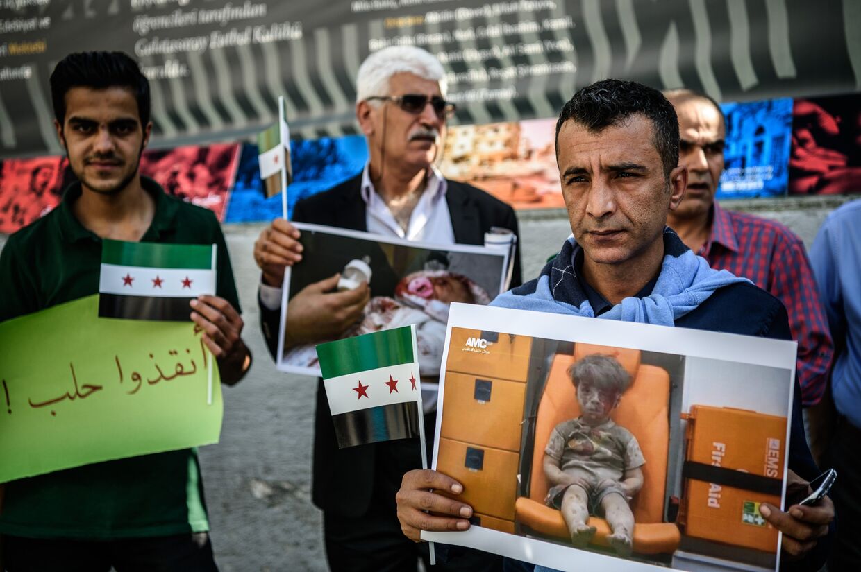 Сирийцы, живущие в Турции, с портретами мальчика Омрана, пострадавшего при обстреле Алеппо. 1 октября 2016