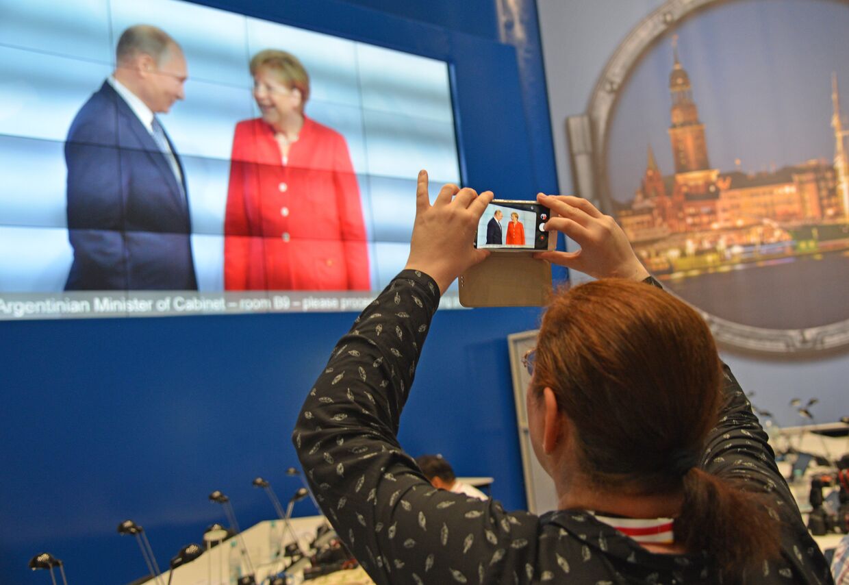 Журналисты в международном пресс-центре во время трансляции официальной встречи президента РФ Владимира Путина канцлером Германии Ангелой Меркель
