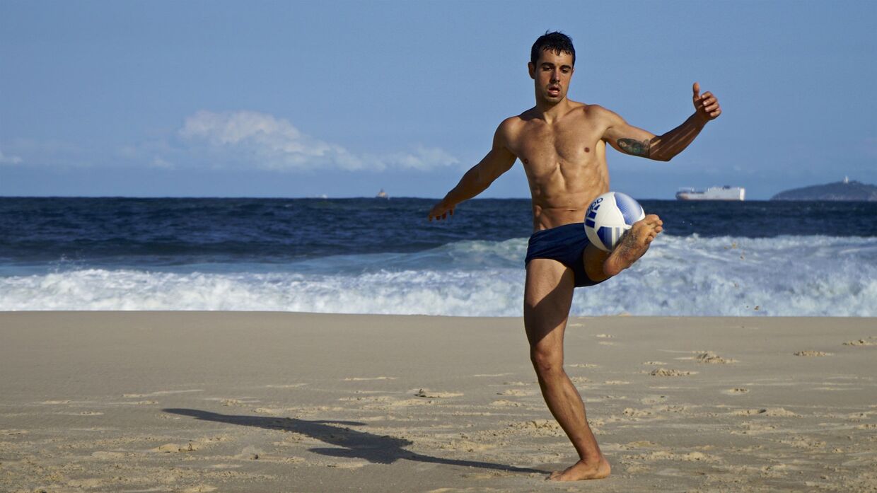 Парень играет в мяч на пляже в Рио-де-Жанейро, Бразилия
