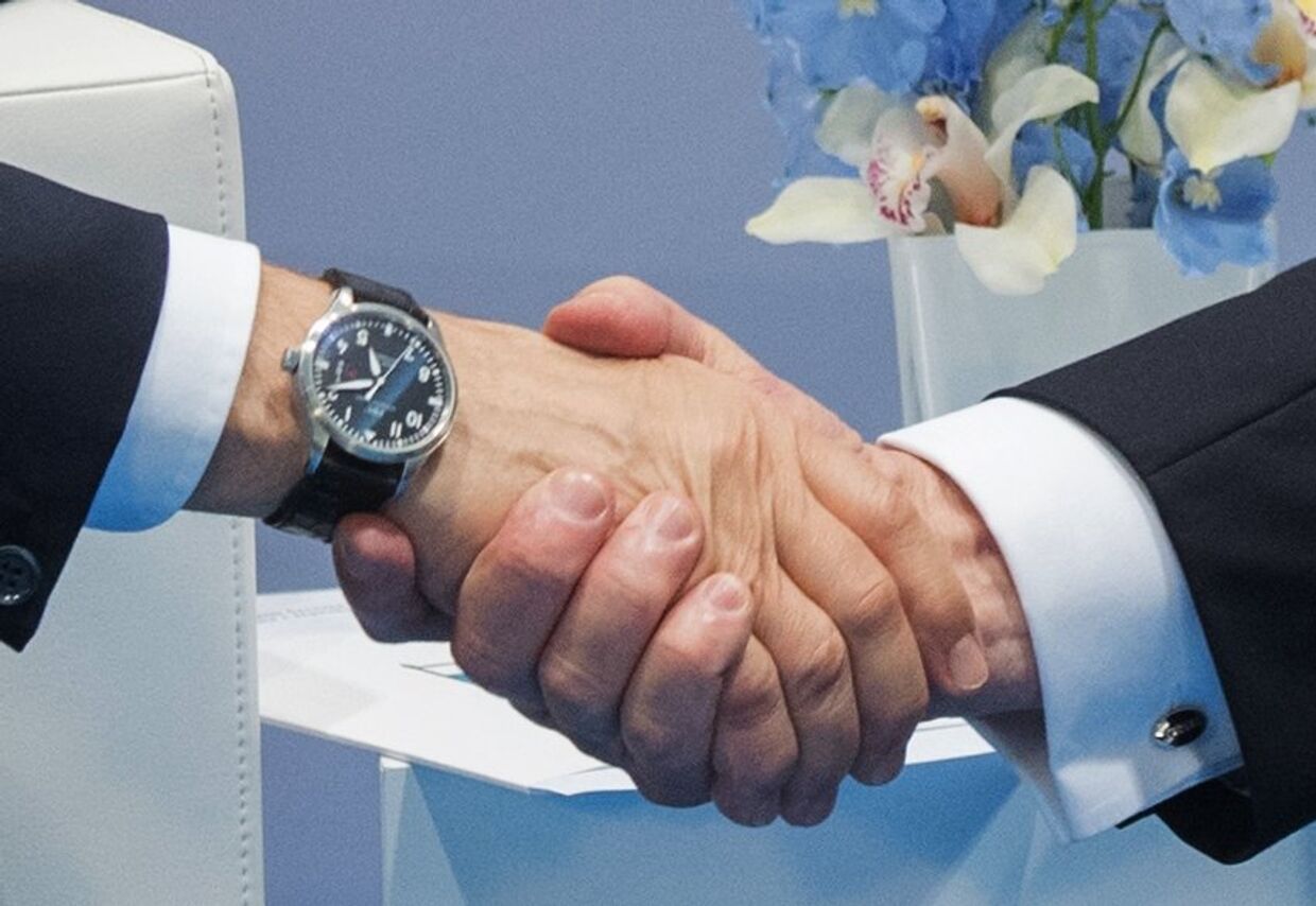 Рукопожатие президента РФ Владимира Путина и президента США Дональда Трампа во время беседы на полях саммита лидеров Группы двадцати G20 в Гамбурге. 7 июля 2017