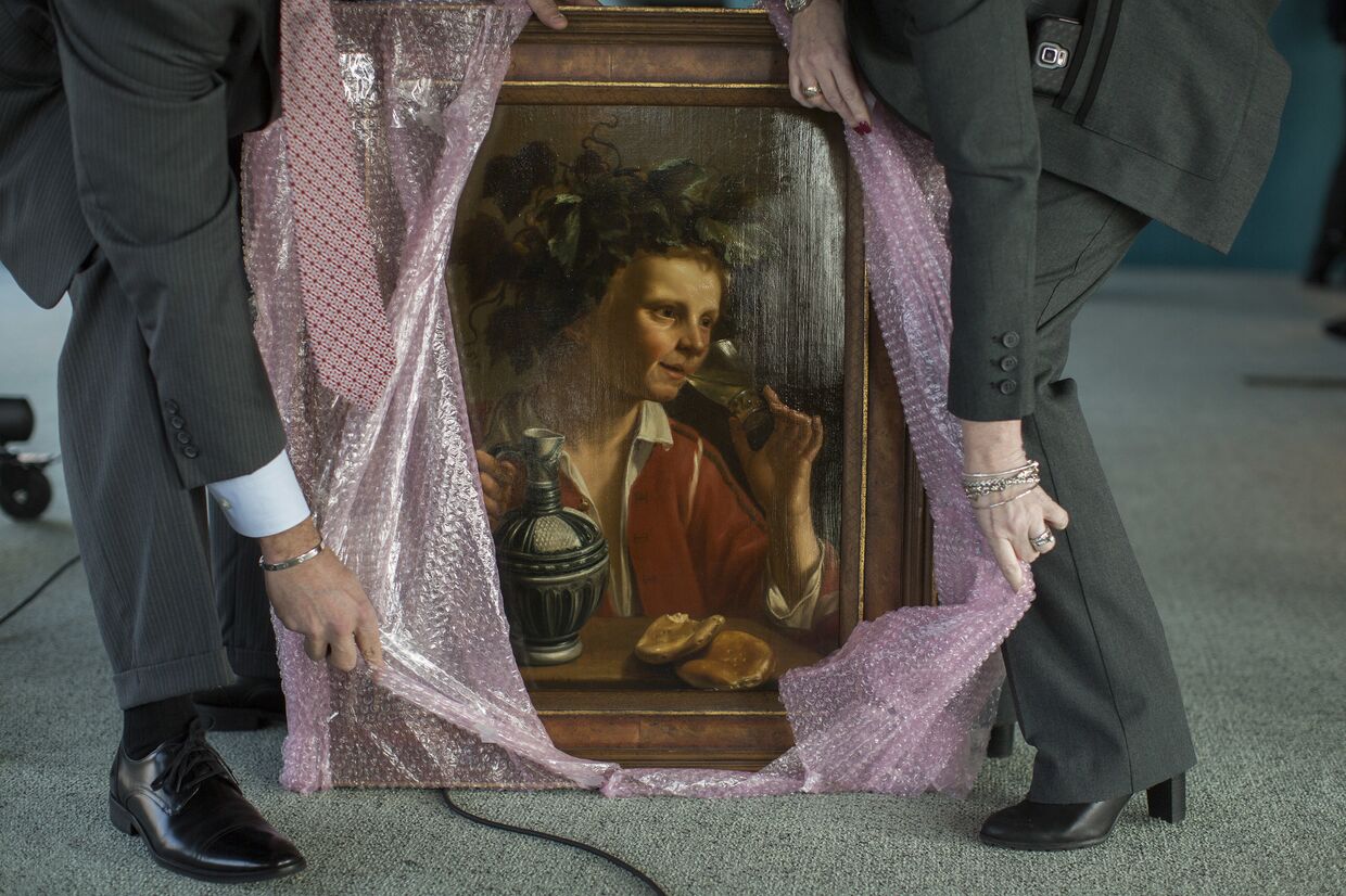 Агенты ФБР распаковывают картину «Молодой человек, как Бахус» Жана Франса Верзийля из «коллекции» нацистов