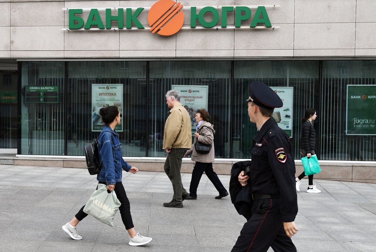 Прохожие у одного из филиалов банка Югра в Москве