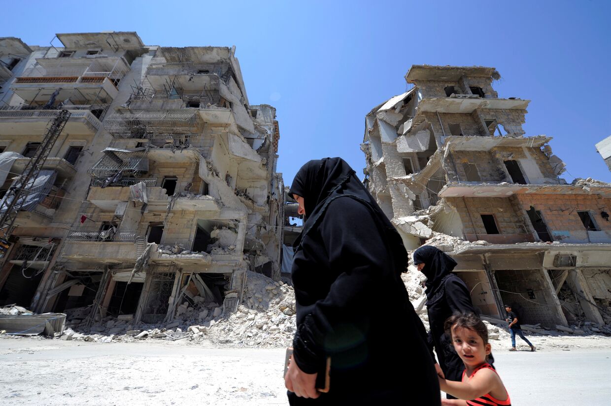 Местные жители на фоне руин в Алеппо, Сирия