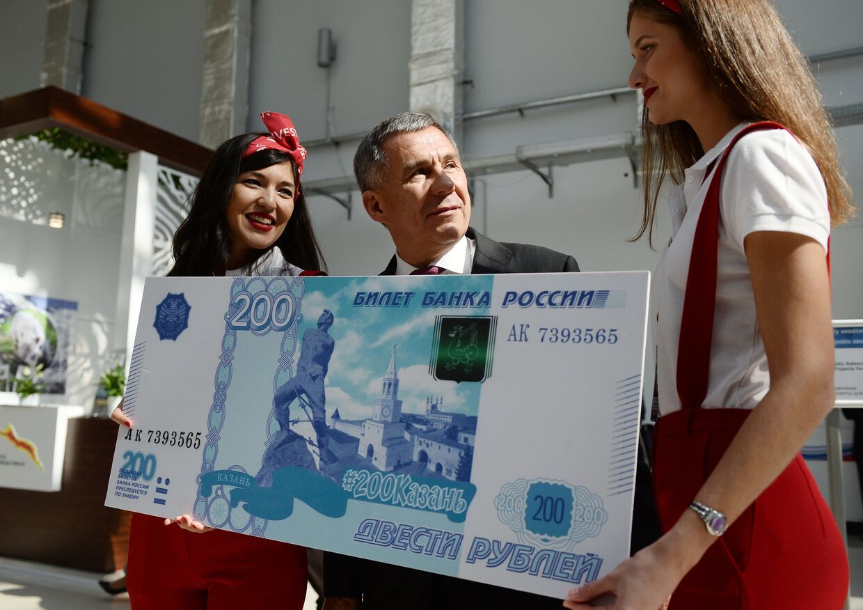 Президент Республики Татарстан Рустам Минниханов фотографируется с образцом банкноты в 200 рублей на международном инвестиционном форуме Сочи 2016